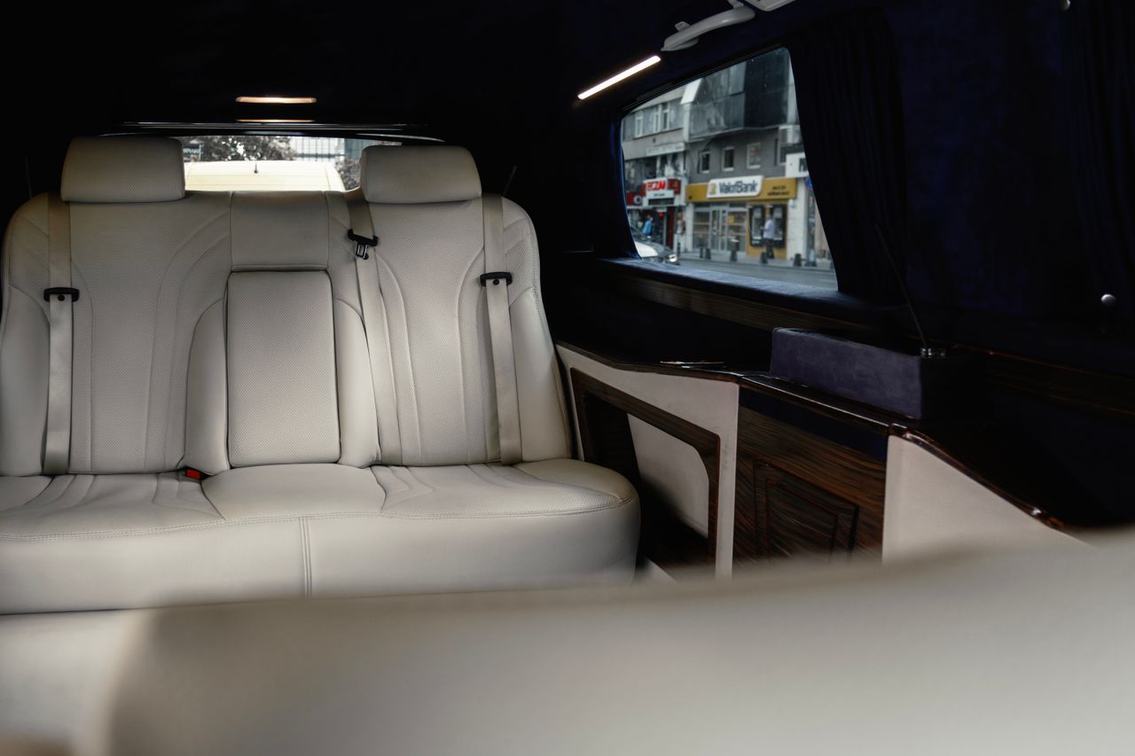 Services Elegant white leather seats in a Mercedes-Benz V-Class with urban view.