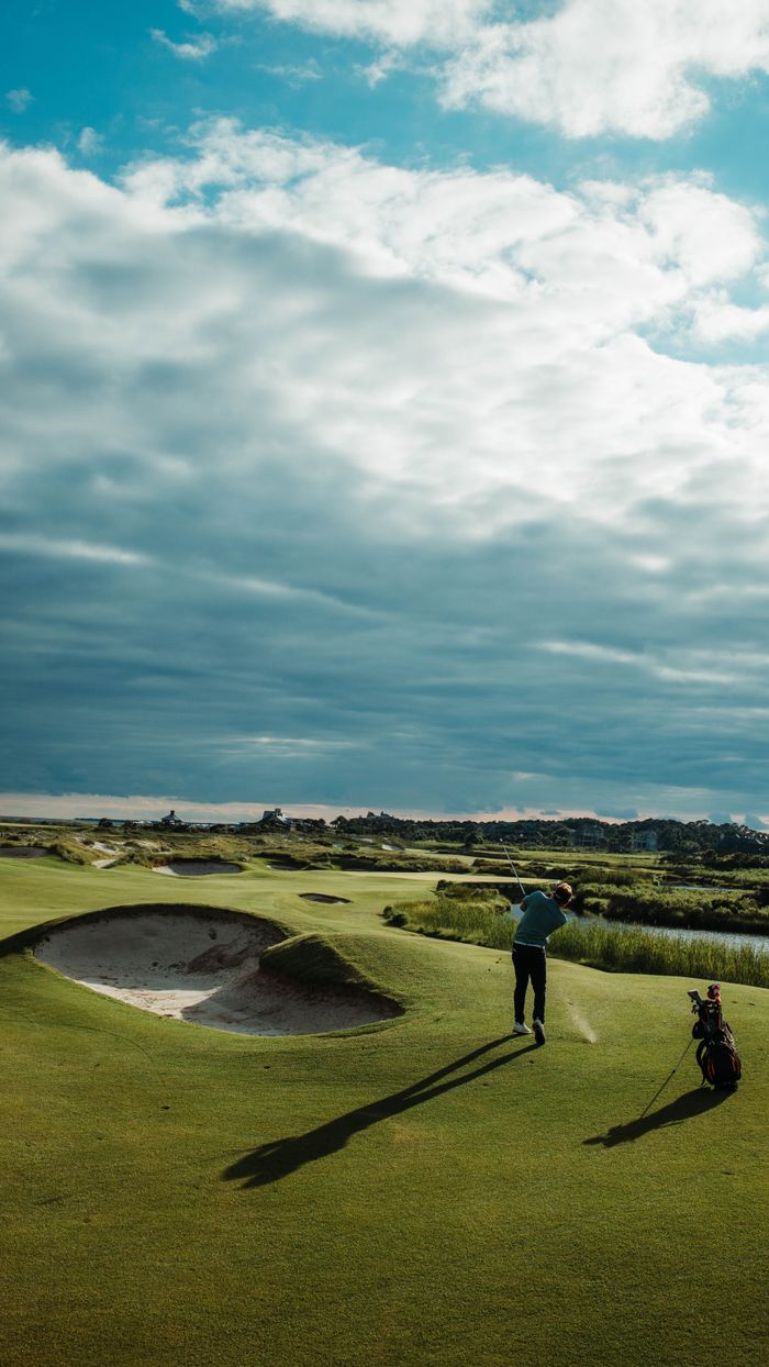 Services Golfer playing on scenic golf course, Kiawah Island, SC, with dramatic cloudy sky.